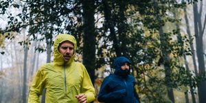 trail runners run through forest on rainy day