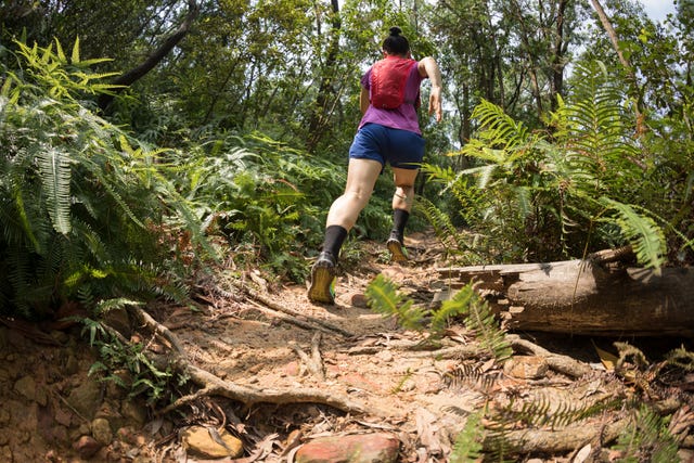 woman trail runner running in tropical forest