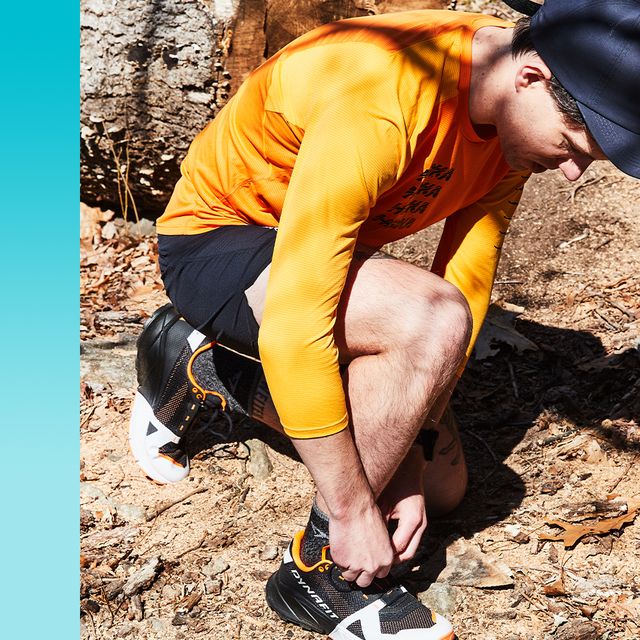 man tying shoes on trail in running gear