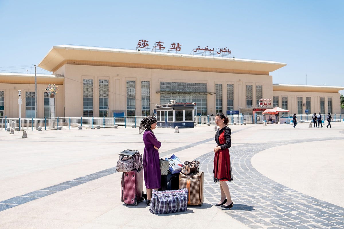 Twee vrouwen wachten voor het station van Shache van oudsher bekend als Yarkand op de trein Shache is een van de grootste steden van de Autonome Regio Xinjiang in China