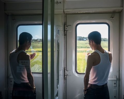Een passagier kijkt uit het raampje van de trein van Beijing naar Pyongyang