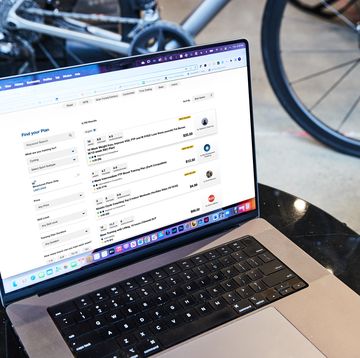 a laptop on a table with a bike in the background