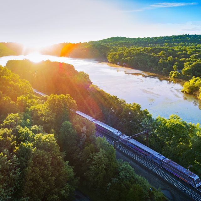 Aerial view of train passing by Estling Lake on sunny day