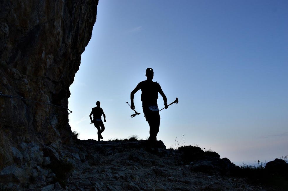 a couple of people climbing a rock