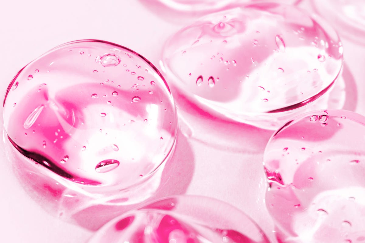 transparent pink moisture face serum smeared hydrating hyaluronic acid hair gel with bubbles cosmetic products for makeup and skin care cosmetology
