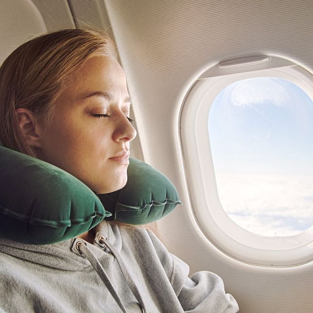 woman using green travel pillow