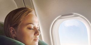 woman using green travel pillow