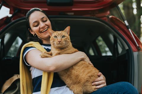 woman holding cat in car
