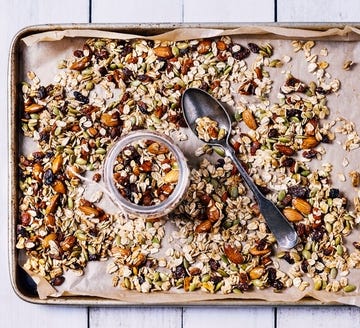 tray of granola on white, wooden background for good housekeeping's best high calorie snacks