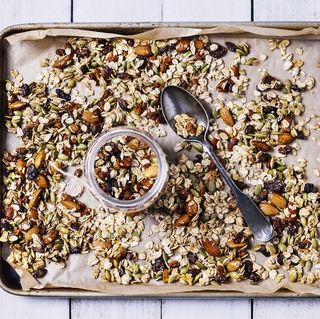 tray of granola on white, wooden background for good housekeeping's best high calorie snacks