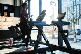 a person running on a treadmill in front of a large window