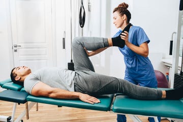treatment of a knee injury to a patient in a hospital exercises to restore the knee physiotherapist examines leg condition
