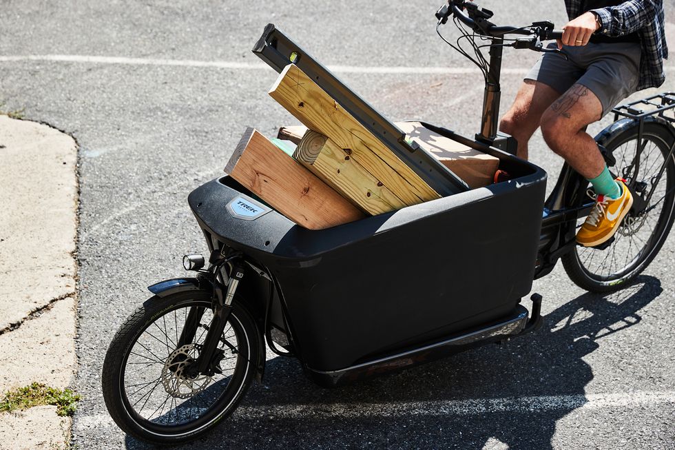 a man riding a bike with a cart full of boxes
