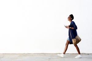 Trendy black woman listening music on mobile phone