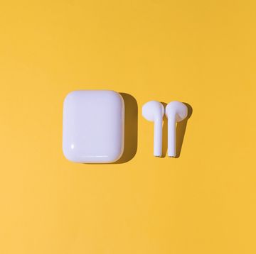 trendy cordless white headphones on yellow background
