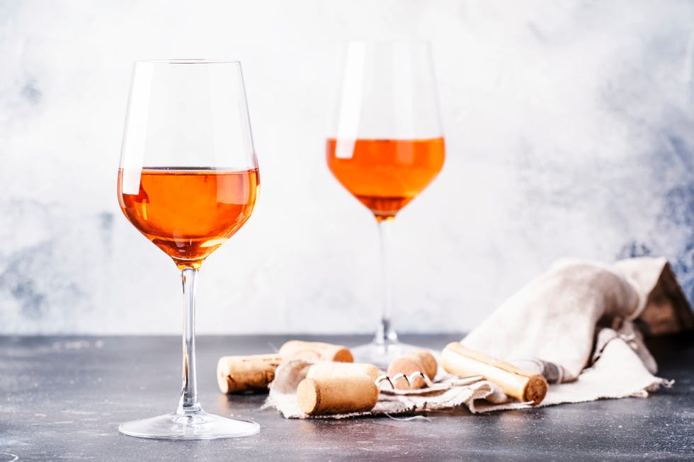 trendy food and drink, orange wine in glass, gray table