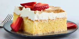 tres leches cake topped with whipped cream and cinnamon