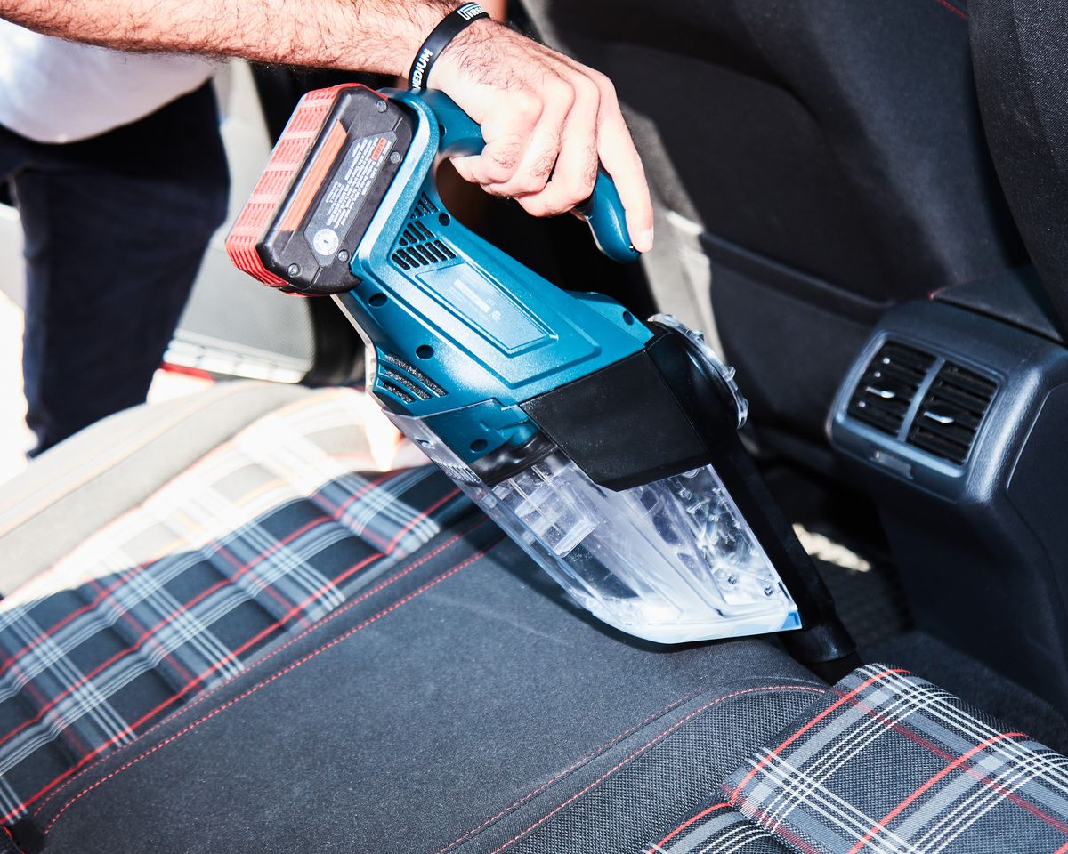 cleaning backseat with a car vacuum