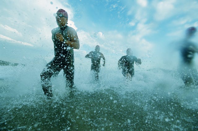 Tri-atheletes running on surf