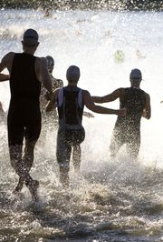 Triathletes At Start of Triathlon Running Into The Water.