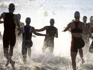 Triathletes At Start of Triathlon Running Into The Water.