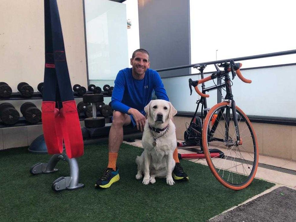 El triatleta paralímpico Jota junto a su perro guía en la terraza de su casa. 