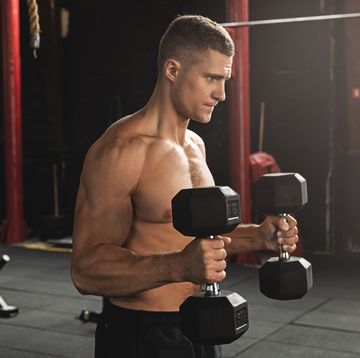 young handsome bodybuilder working out with dumbbells bicep hammer curl exercise
