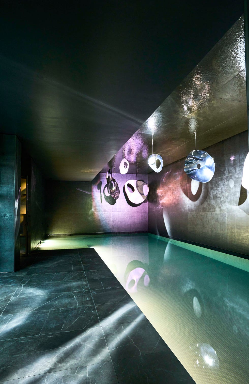 underground swimming pool with mood lighting and art installation on wall
