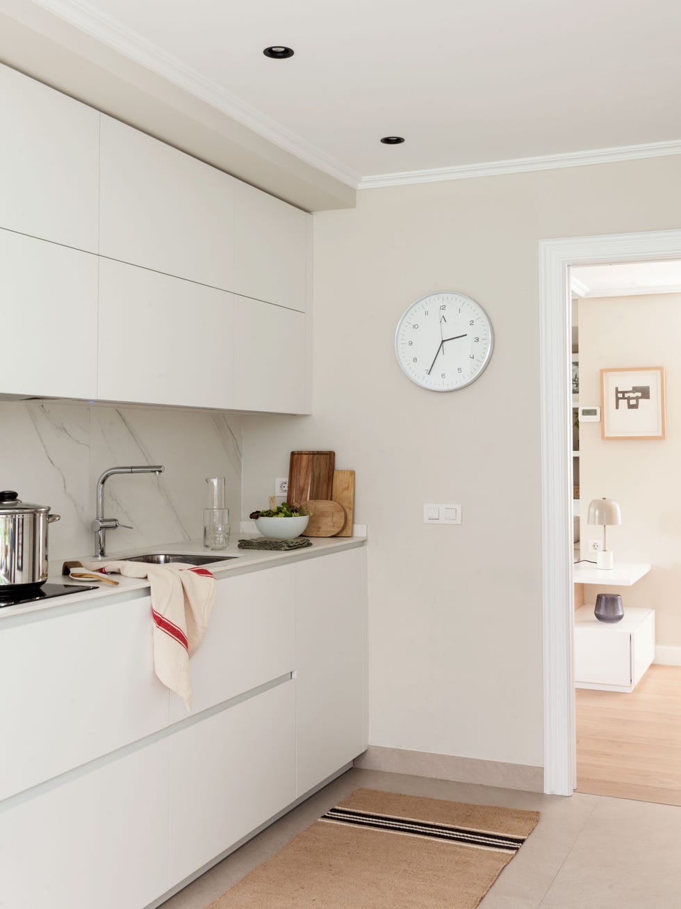 cocina blanca de diseño moderno con armarios sin tiradores y encimera y frente efecto mármol