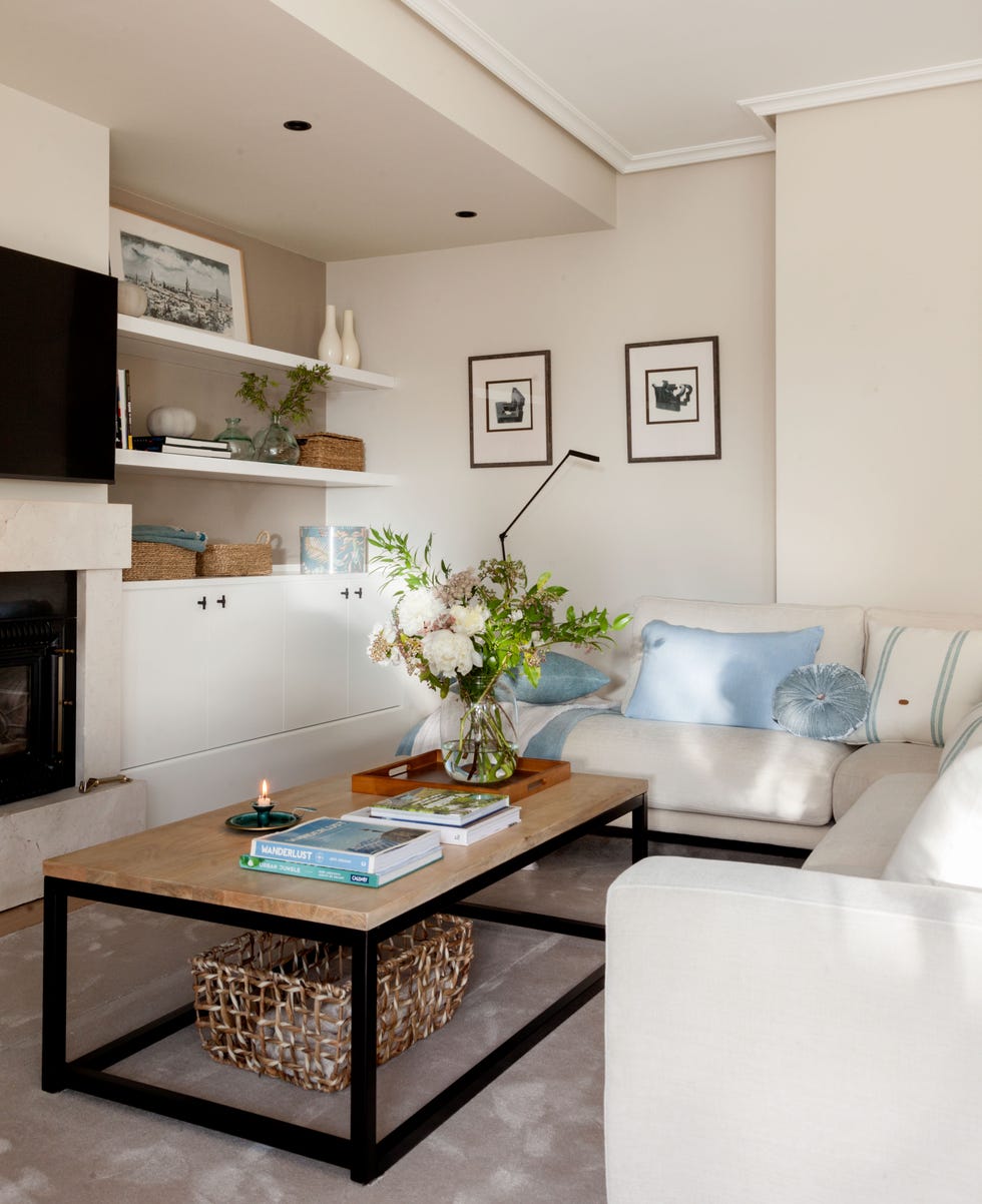 salón con sofá rinconero blanco y mesa de centro de madera y acero