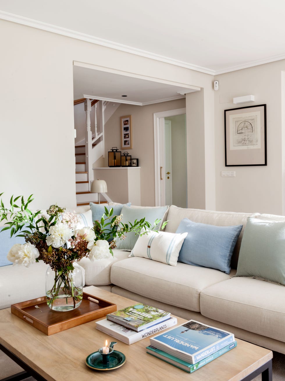 salón con sofá rinconero blanco y mesa de centro de madera y acero