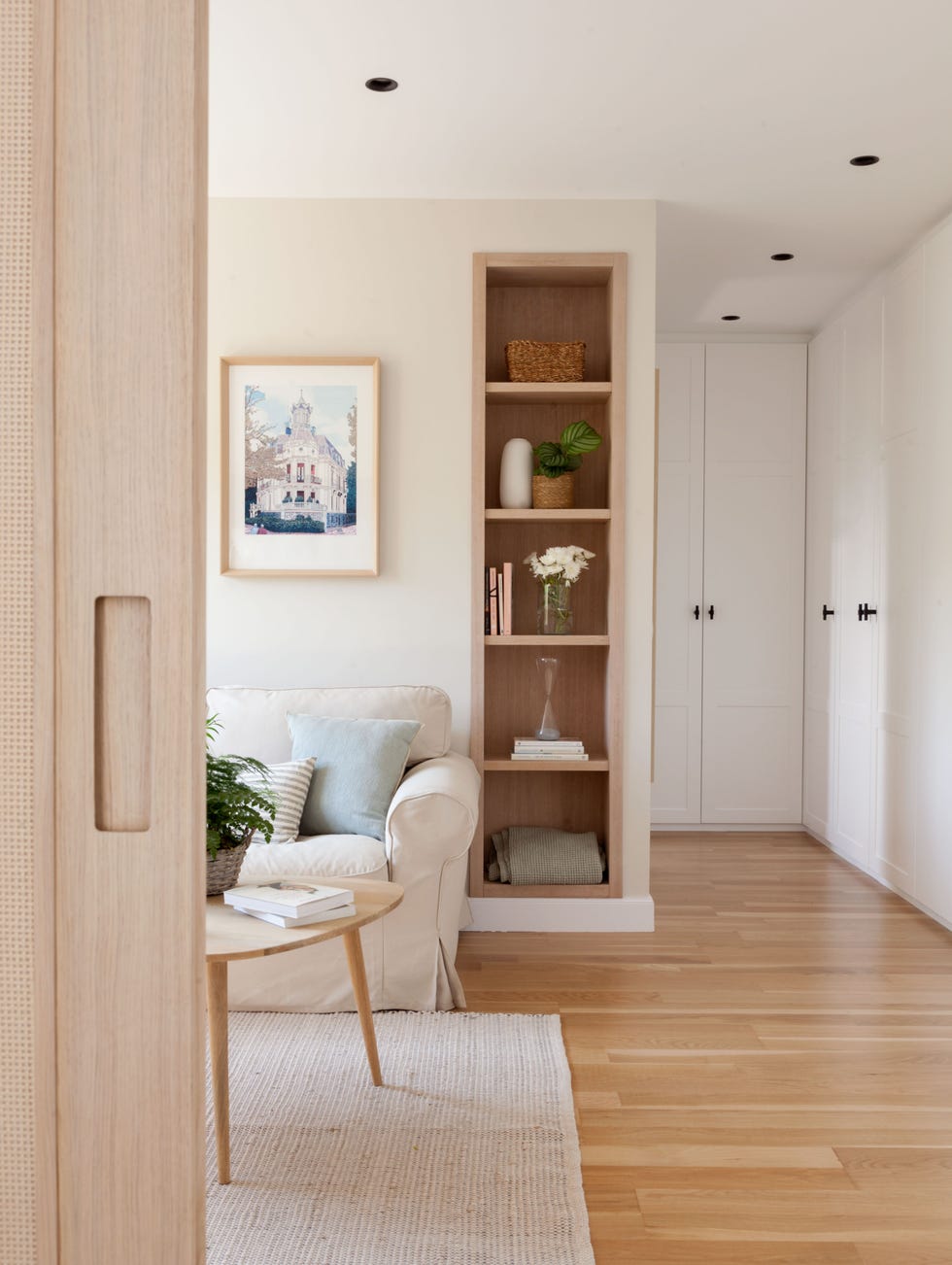 sala de estar con sofá clásico beige y estantería de madera empotrada