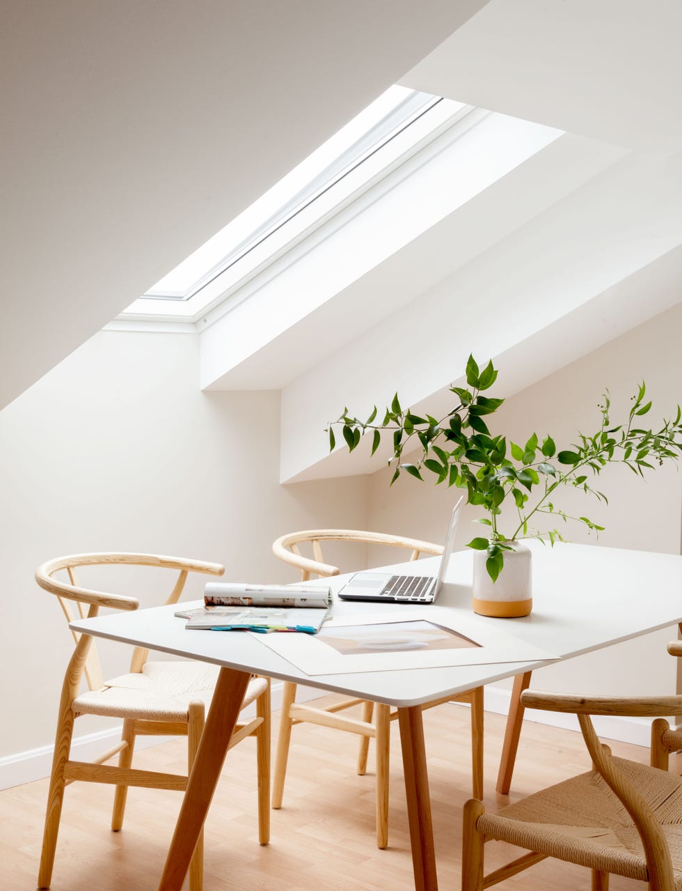 mesa blanca nórdica de comedor con sillas de madera y ratán