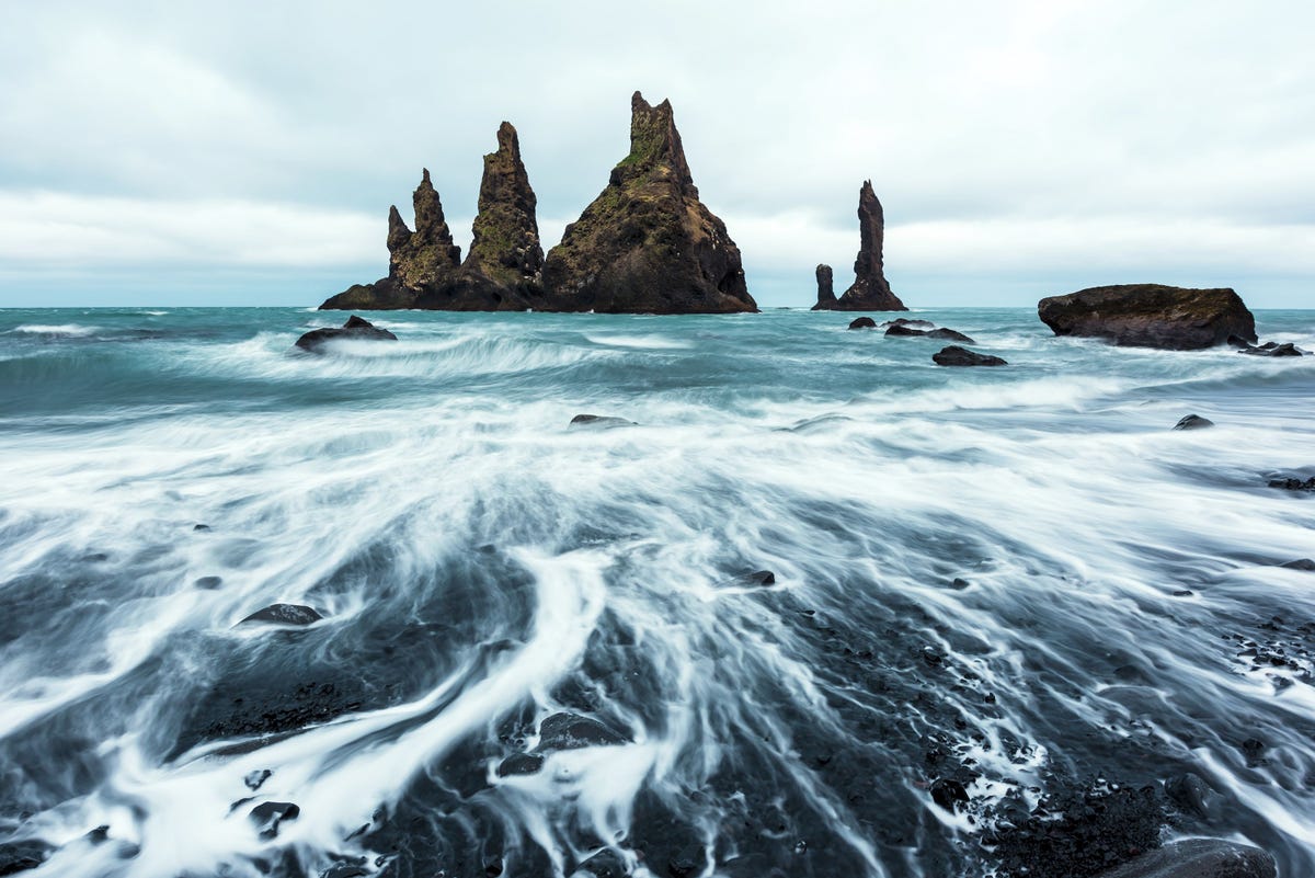 Basaltformaties die volgens de overlevering de tenen van versteende trollen zijn op het zwarte strand van Reynisdrangar bij Vik IJsland
