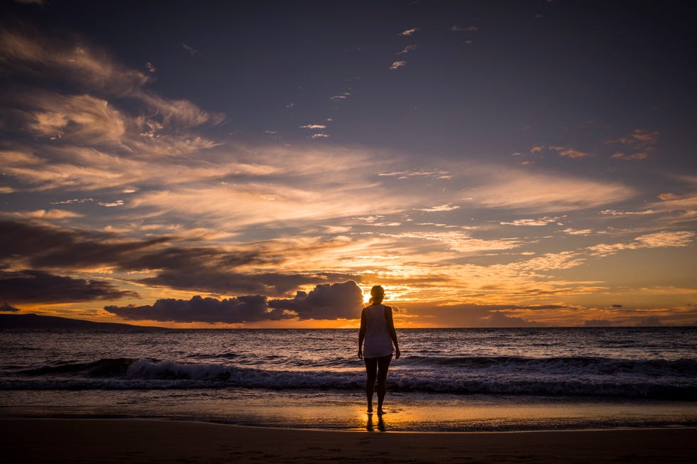 woman watching sunset on beach in maui