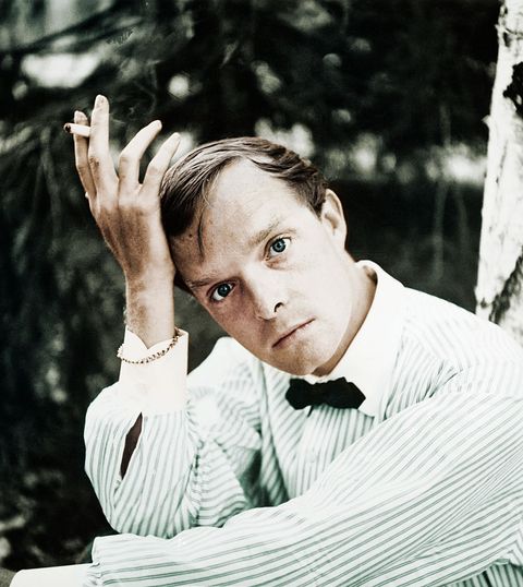author truman capote posing outdoors with cigarette
