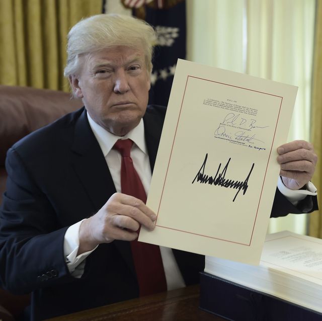 topshot   united states president donald j trump holds up a document during an event to sign the tax cut and reform bill in the oval office at the white house in washington, dc on december 22, 2017  afp photo  brendan smialowski        photo credit should read brendan smialowskiafp via getty images