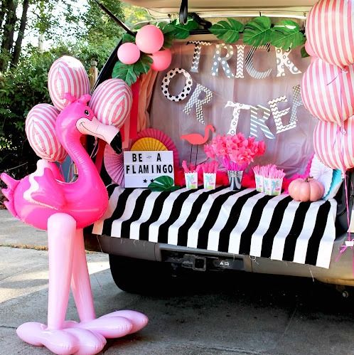 stripes and all things pink, plus an inflatable flamingo, make up a trunk or treat setup