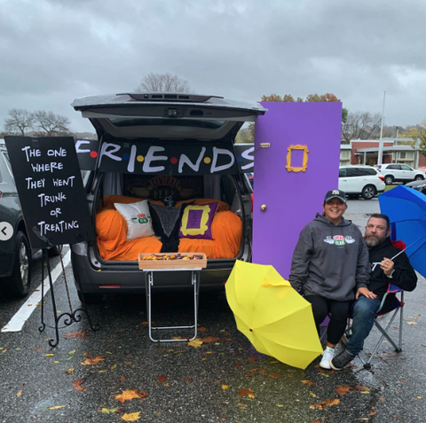 a car decked out for trunk or treat with a friends theme including colorful umbrellas and a recreation of the purple door from friends