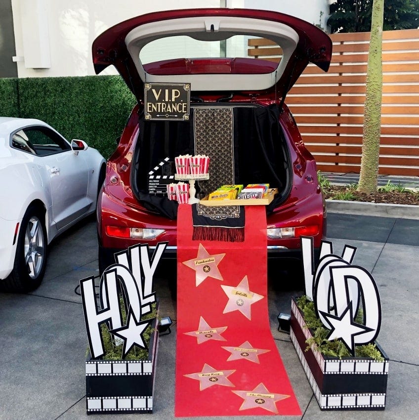 trunk or treat in a hollywood movie red carpet theme with a red carpet and hollywood sign with treat and popcorn boxes