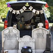 a car decked out for trunk or treat in a hocus pocus theme with gravestones, cauldrons, witch hats and more