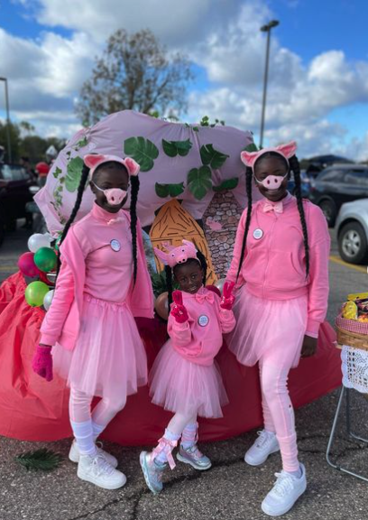 a car decked out for trunk or treat in a three little pigs theme wit hthree houses and kids dressed as the fairytale characters