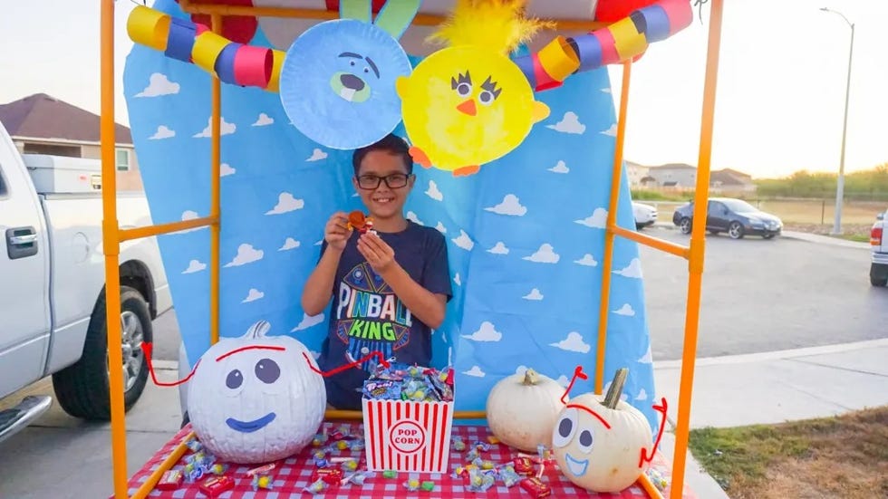 a car decked out for trunk or treat in a toy story 4 theme with a carnival booth, forky pumpkins and ducky and bunny decorations