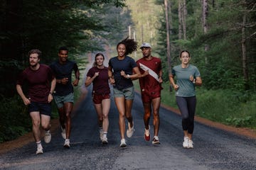 group of runners jogging on a forested road