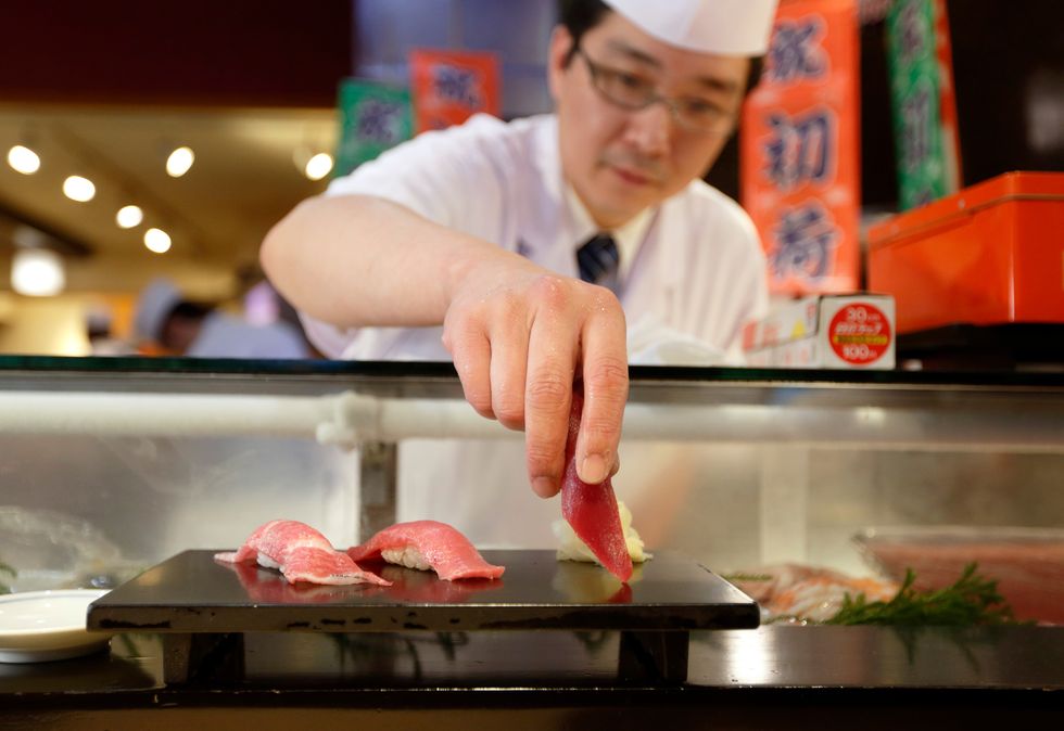 tokyo, japan january 05 a sushi chef serves a piece of tuna sushi at a sushi zanmai sushi restaurant, operated by kiyomura kk, after the year's first auction at tsukiji market on january 5, 2016 in tokyo, japan kiyomura kk, which operates the sushi zanmai sushi restaurant chain, bid the highest priced tuna weighing 200 kilogram 441 pound for 14 million yen $117,306 at the year's first auction photo by tomohiro ohsumigetty images
