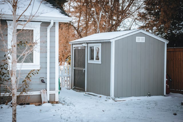 a grey outdoor tuff shed storage shed in a snowy backyard
