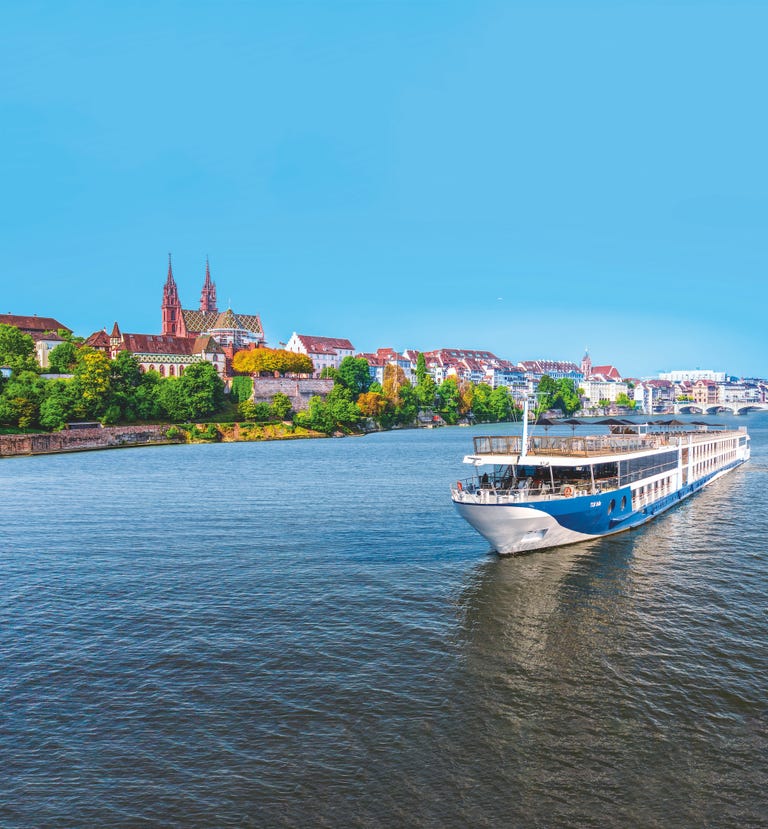 river cruise ship navigating along a river with a scenic town in the background