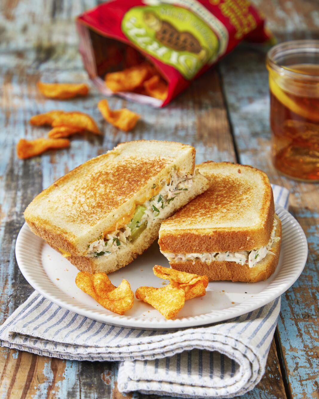 tuna melt sandwich on a plate with some chips