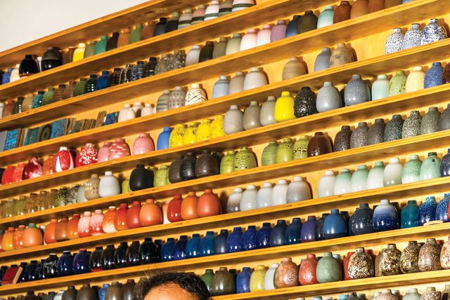 tung chiang, the director of heath ceramics’ clay studio in san francisco, in front of the company’s signature bud vases