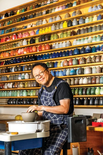 tung chiang, the director of heath ceramics’ clay studio in san francisco, in front of the company’s signature bud vases